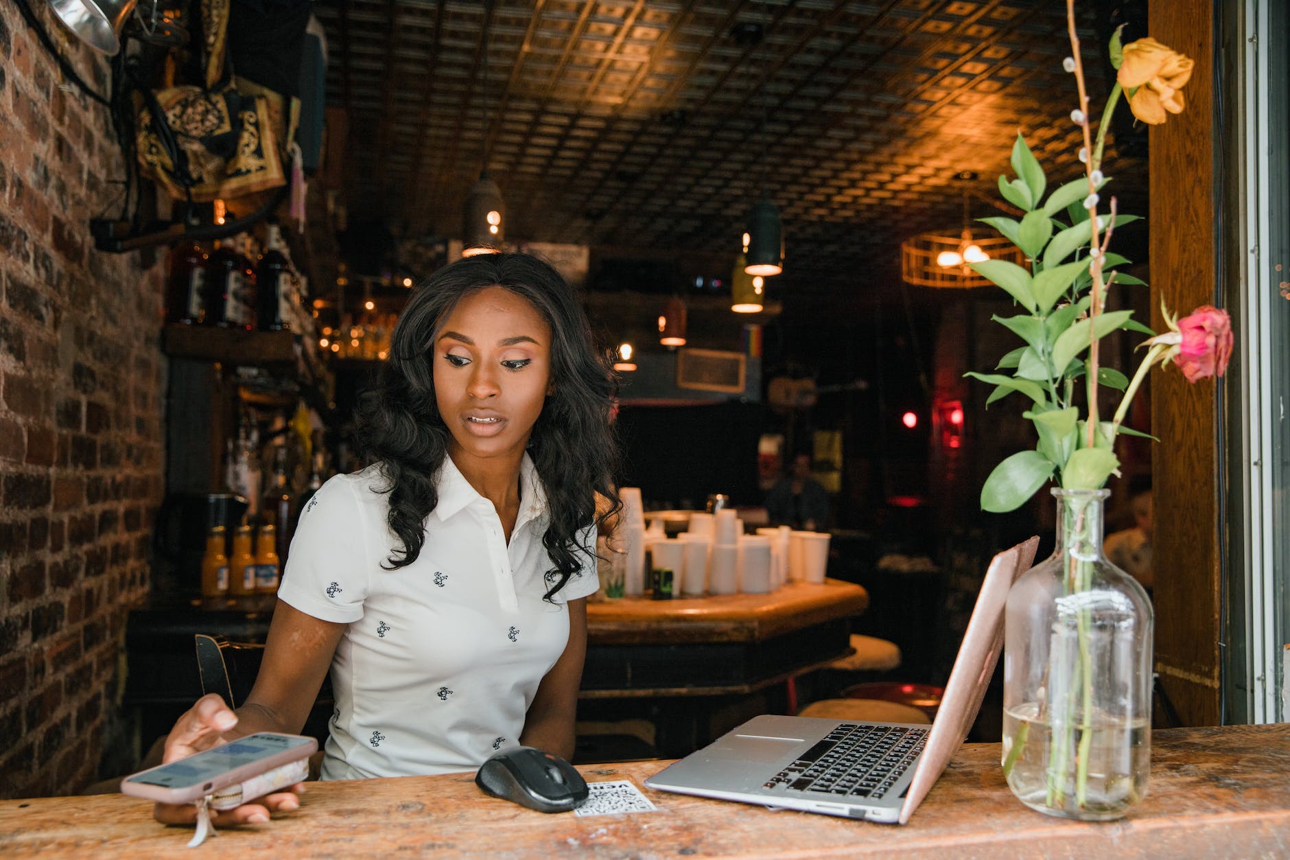 Woman Using Laptop and Smart Phone at Cafe